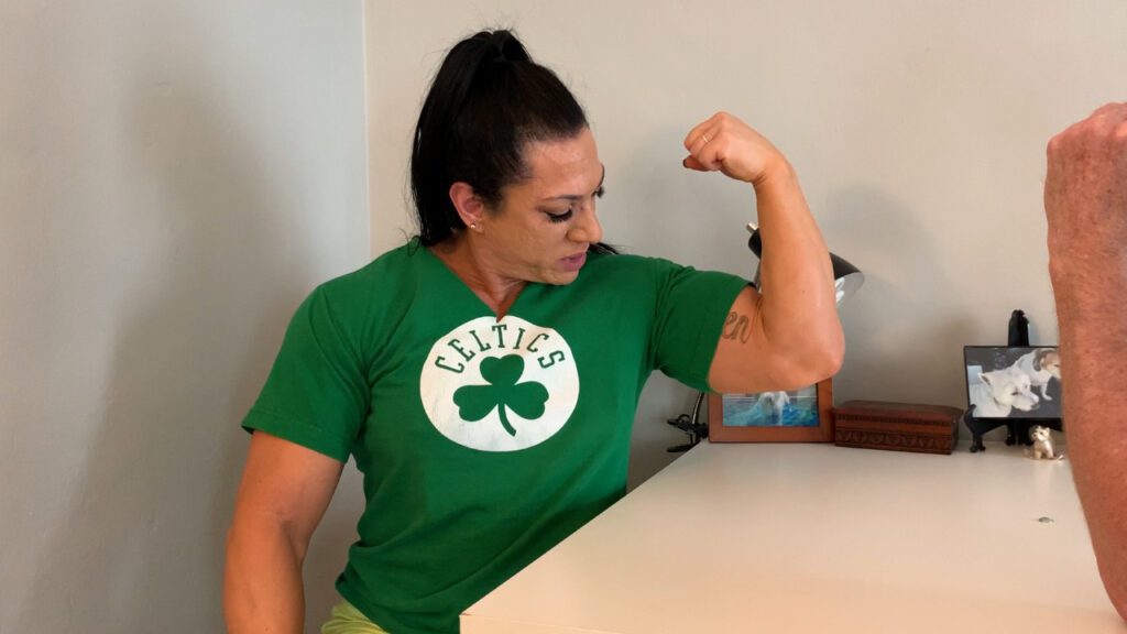 RippedVixen, Green Celtics Shirt, flexing left bicep, intimidating